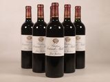 quatre bouteilles de vin rouge sont alignées sur une table