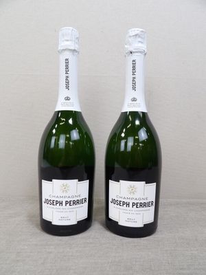 deux bouteilles de champagne posées l'une à côté de l'autre sur une table