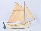 un petit bateau muni d'une voile sur une surface blanche