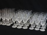 douze verres à vin en cristal alignés sur un fond noir