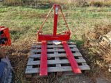 un chariot élévateur rouge posé sur une palette dans un champ