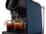 a blue coffee machine with two cups of coffee in front of it