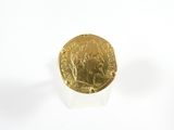 une pièce d'or posée sur une surface blanche