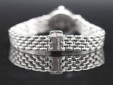 a close up of a silver bracelet on a black surface