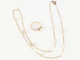 a white and gold necklace, ring, and bracelet on a white background