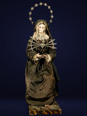 a statue of a woman in a black dress with stars on her head