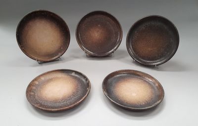 four brown plates sitting on top of each other on a table
