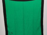 a close up of a green and black blanket hanging on a wall