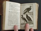 a person holding an open book with birds on it