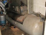 un grand réservoir posé dans un garage, à côté d'un climatiseur