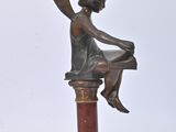 bronze statue of a woman sitting on a pedestal with a book