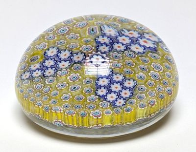 une boule en verre jaune et bleue décorée de fleurs