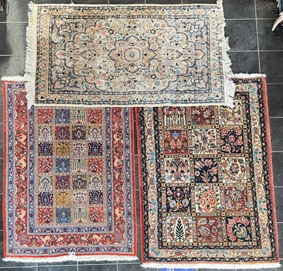 trois tapis orientaux posés sur un sol carrelé dans une pièce