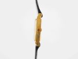a close up of a black and gold clock on a wire