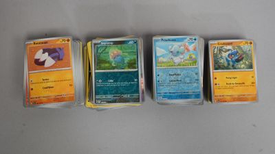 Quatre cartes Pokémon différentes sont alignées sur une table