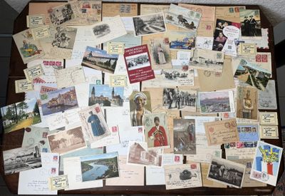 de nombreuses cartes postales anciennes posées sur une table, dont il y a beaucoup