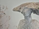 une statue représentant une femme avec un oiseau sur la tête