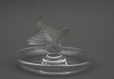 une plaque de verre sur laquelle est posée une fleur en verre