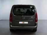 the back of a silver van is parked in a white room