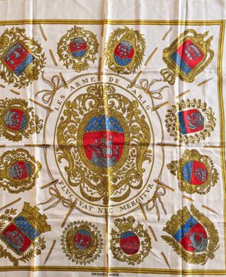 une écharpe blanche et dorée ornée d'emblèmes rouges et bleus