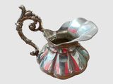 un pichet en argent orné d'une rayure rouge et blanche