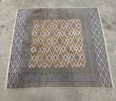 un vieux tapis au motif en losanges posé par terre