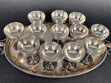 a silver tray that has a lot of silver dishes on it