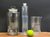 two glass containers and a green apple sitting on a table
