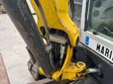 the back end of a yellow and black excavator parked in a parking lot