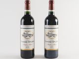 two bottles of red wine sitting next to each other on a white surface
