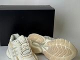 a pair of white sneakers sitting on top of a box