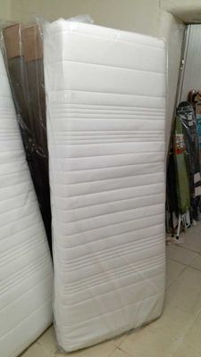 Plusieurs matelas sont empilés les uns à côté des autres dans une pièce.