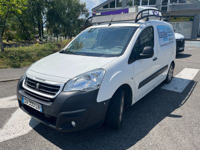 La camionnette blanche est garée sur le bord de la route, devant un immeuble.