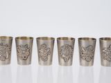 un lot de quatre verres à shot en argent décorés de motifs