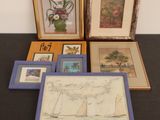 many framed pictures on a table with a picture of a sailboat