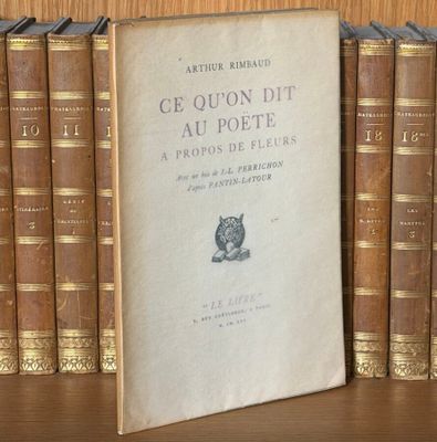 un livre posé sur une étagère devant une pile de livres