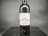 une vieille bouteille de vin posée sur une boîte noire