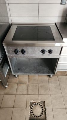 tiled floor in a kitchen with a stove and a sink