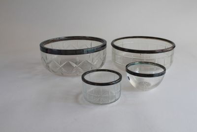 three glass bowls with black rims sitting on a white surface