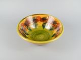yellow and green bowl sitting on top of a white table