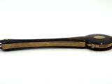 a black and gold hair clip on a white table
