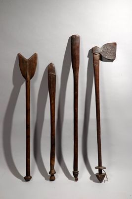 three wooden axes are lined up against a white wall