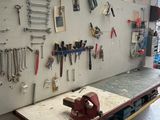 a workbench with a lot of tools hanging on the wall