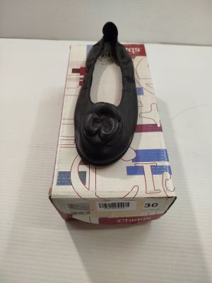une boîte sur laquelle se trouve une paire de chaussures noires