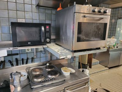 a kitchen with a stove, microwave, and other appliances in it
