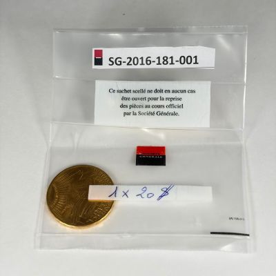 une pièce d'or et un petit bout de papier posés sur une table