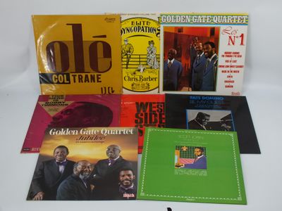 Diverses pochettes d'albums, de styles et de couleurs variés, sont disposées sur une surface blanche