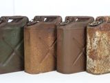 several old metal cans are lined up on a white surface