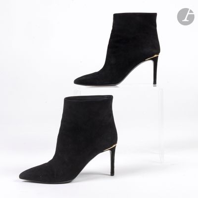 une paire de bottines en daim noir sur une semelle compensée transparente