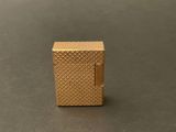 a close up of a gold lighter sitting on a table
